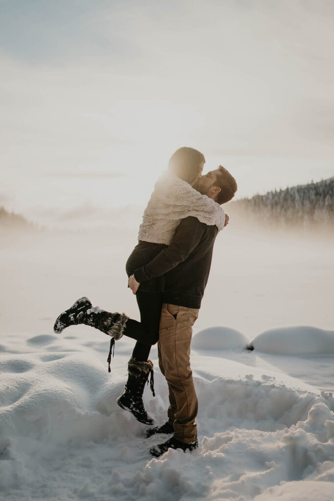 Couple kissing in the snow during winter engagement photos at Mount Hood