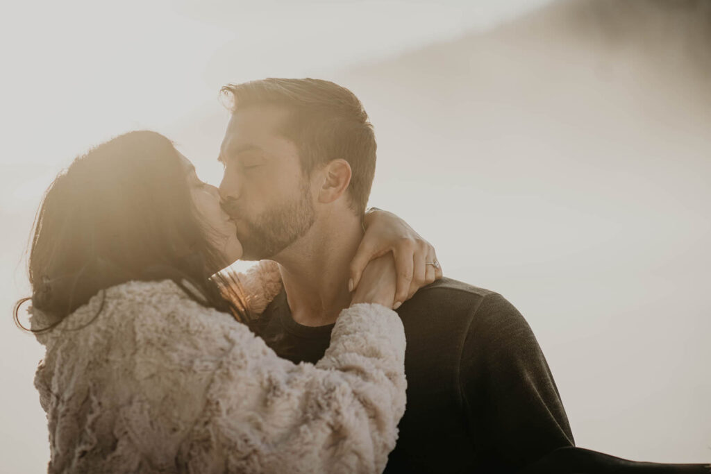 Couple kissing during snow engagement photos