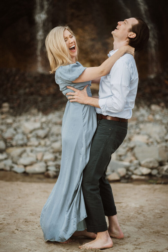 Couple laughing during engagement photo session at Hug Point State Park