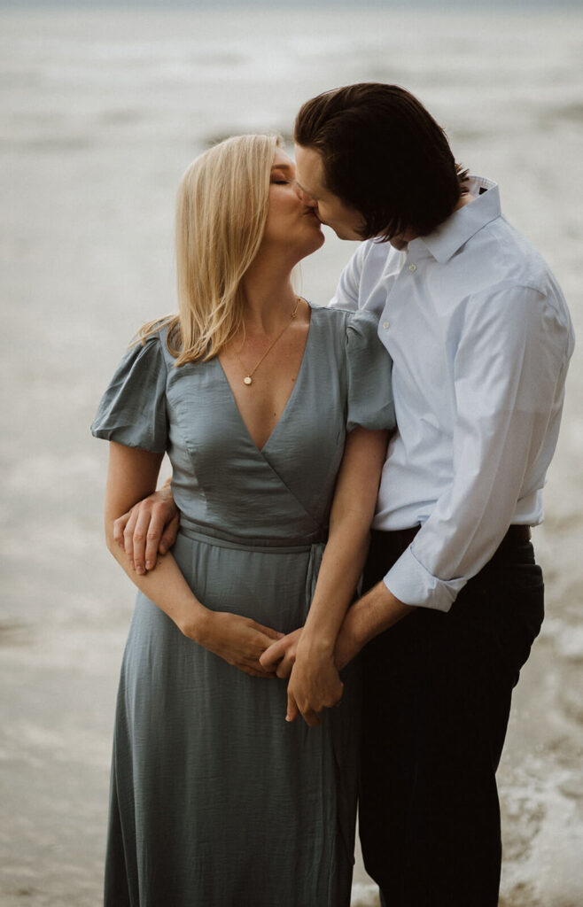 Couple kissing during engagement photo session at Hug Point