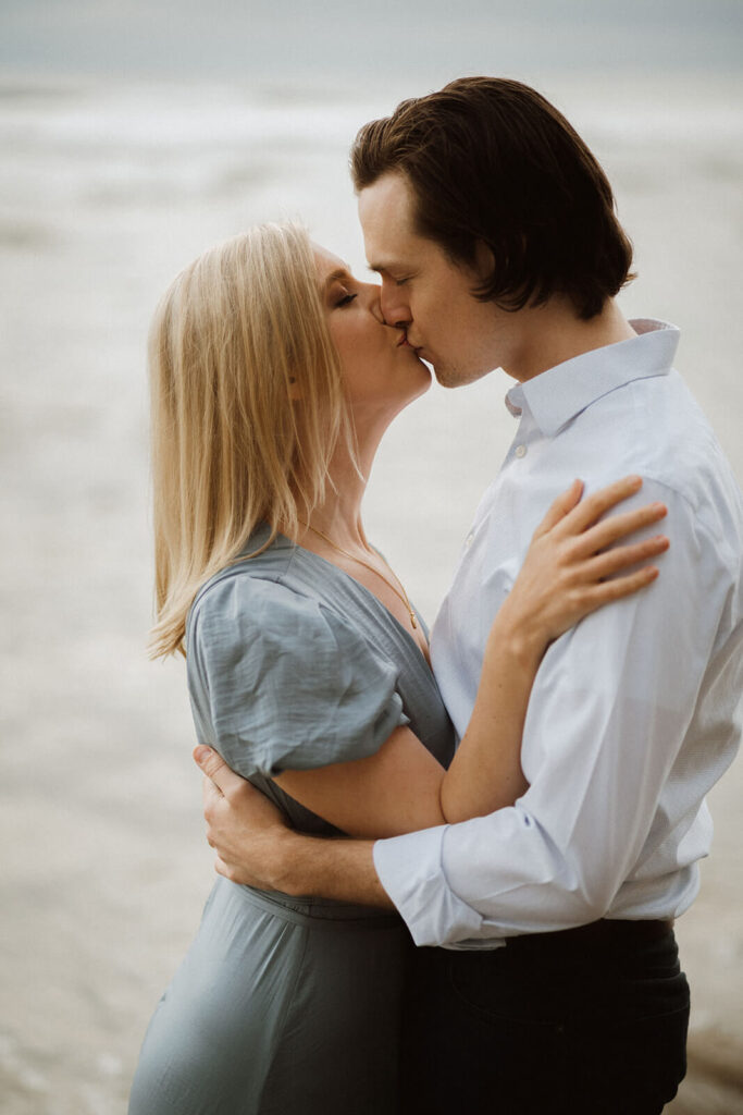 Couple kissing during engagement photo session at Hug Point