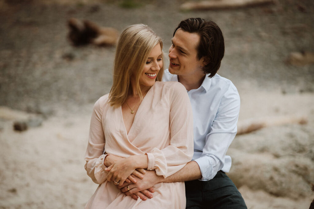 Couples hugging during engagement photos at Hug Point 