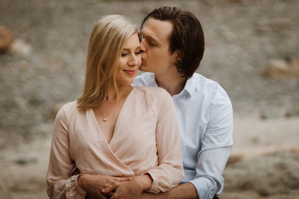 Couple kissing during engagement photo session at Hug Point