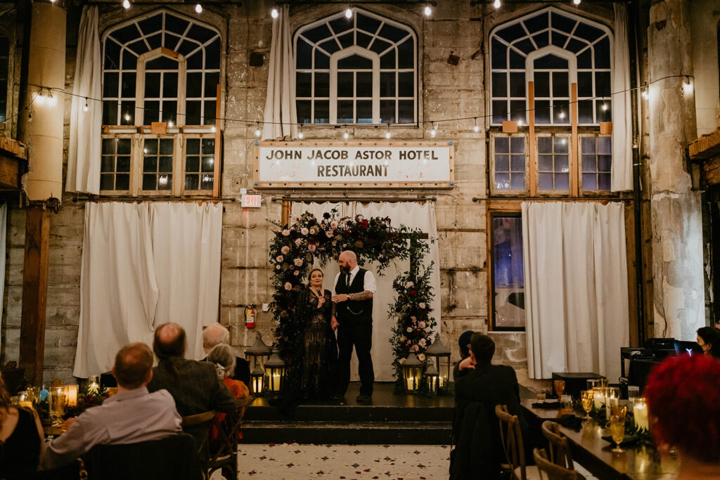 Bride and groom giving speeches at fall wedding reception