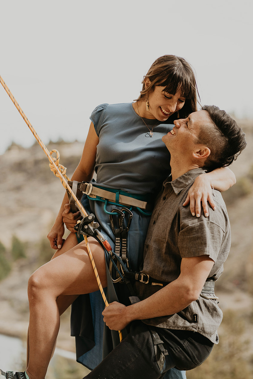 a couple rock climbing during their engagement photo session.