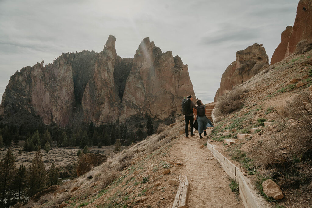 a couple hiking along a path at smith rock state park.