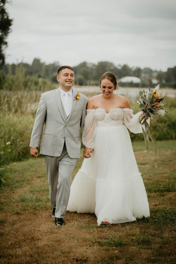 Bride and groom holding hands walking back to their wedding after first look