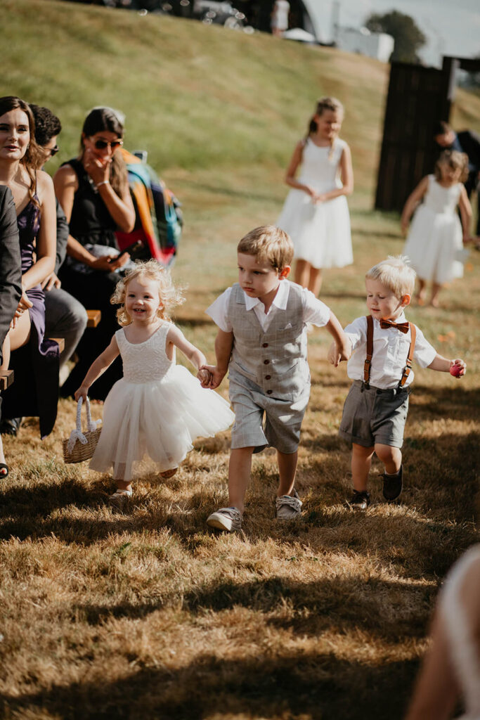 Flower girls and boys run down the aisle at romantic wedding in Washington