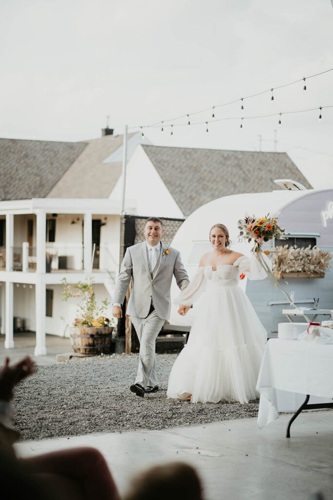 Bride and groom enter wedding reception at Pemberton Farm