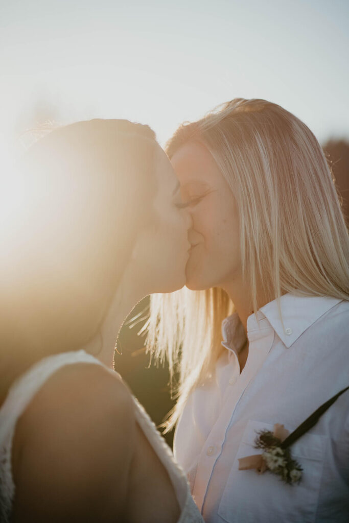 Two brides kissing during Sunrise, Mount Rainier elopement