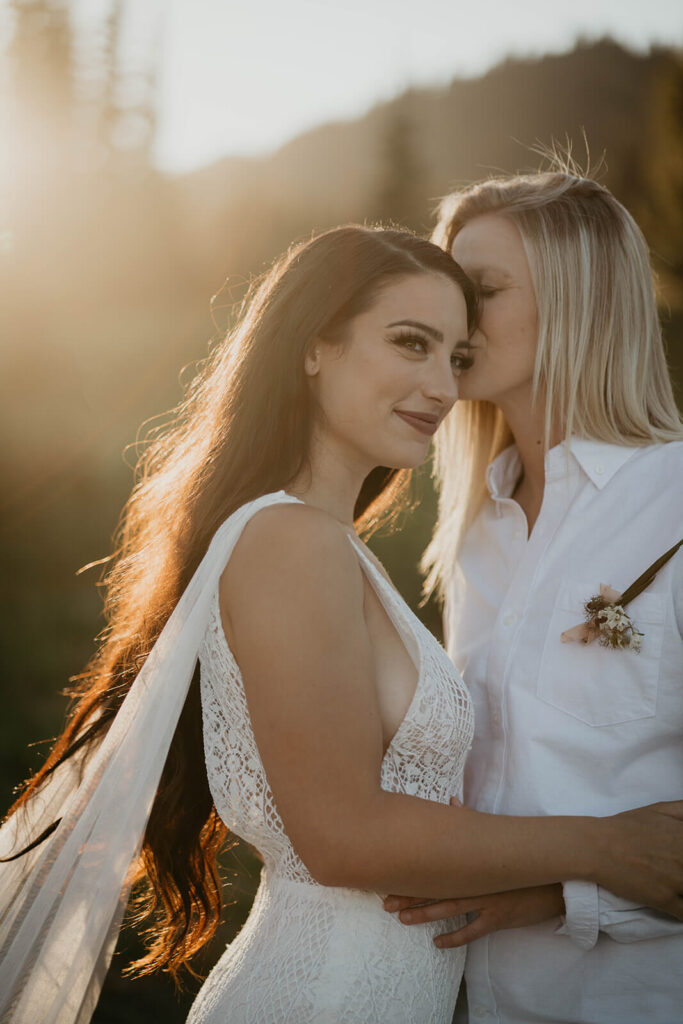 Two brides kissing during Sunrise, Mount Rainier elopement