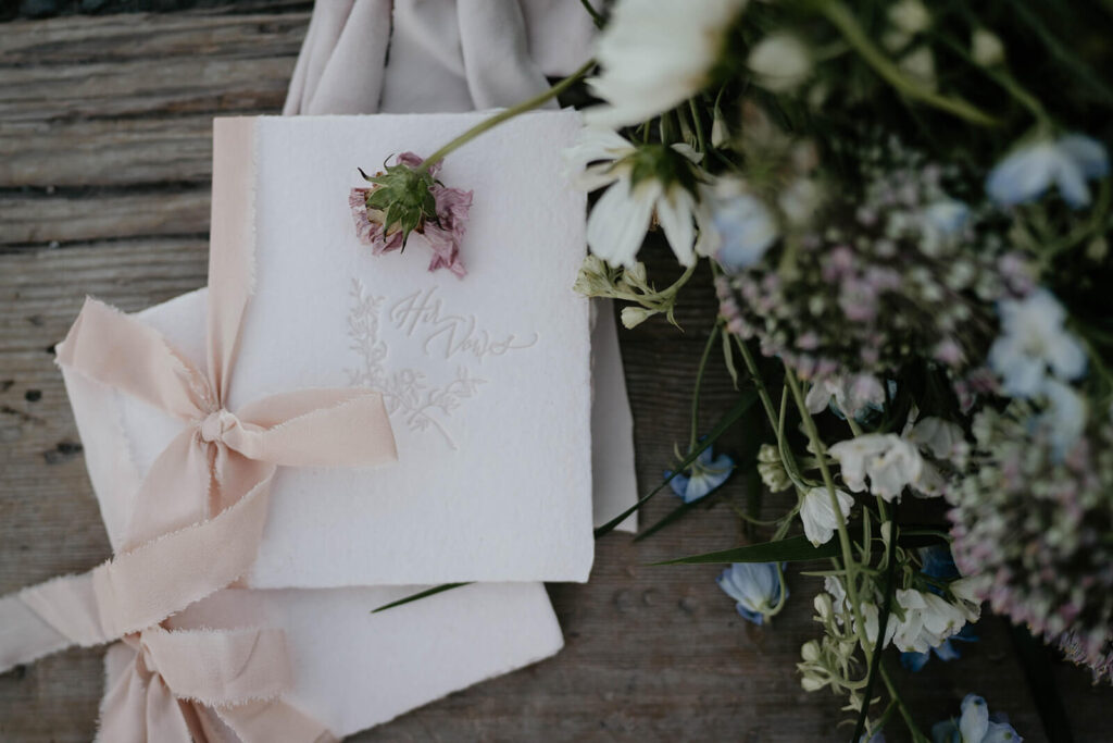 White vow books with pastel pink ribbon