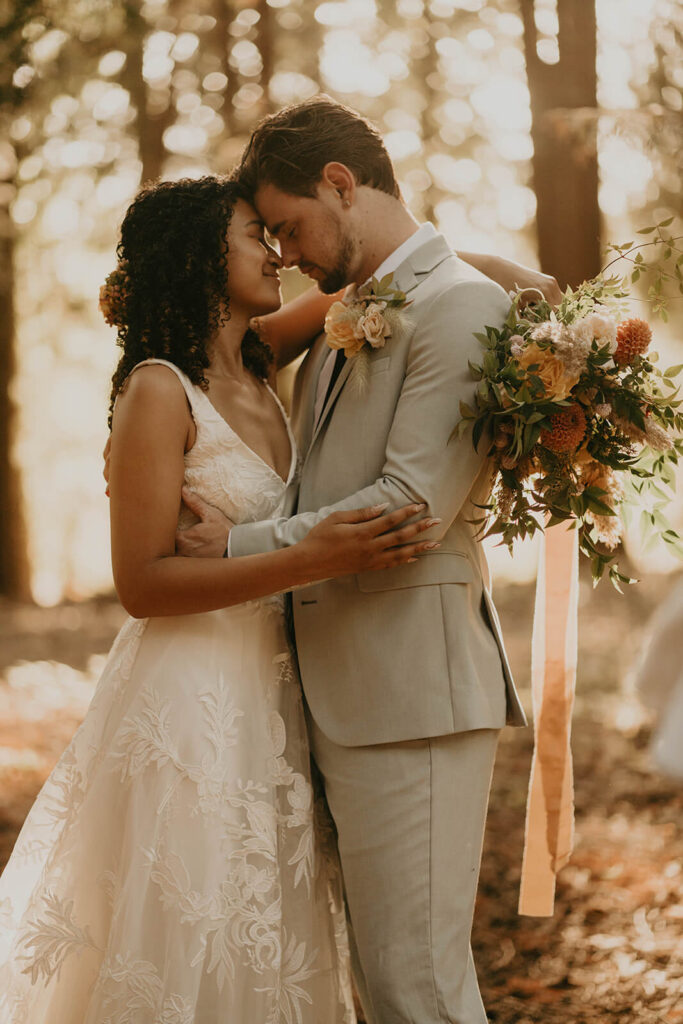 Bride and groom hug after first look in the forest at CedarVale Events