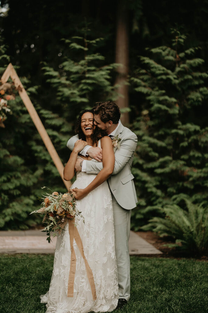 Bride and groom portraits in front of A frame wedding arch at CedarVale Events wedding venue