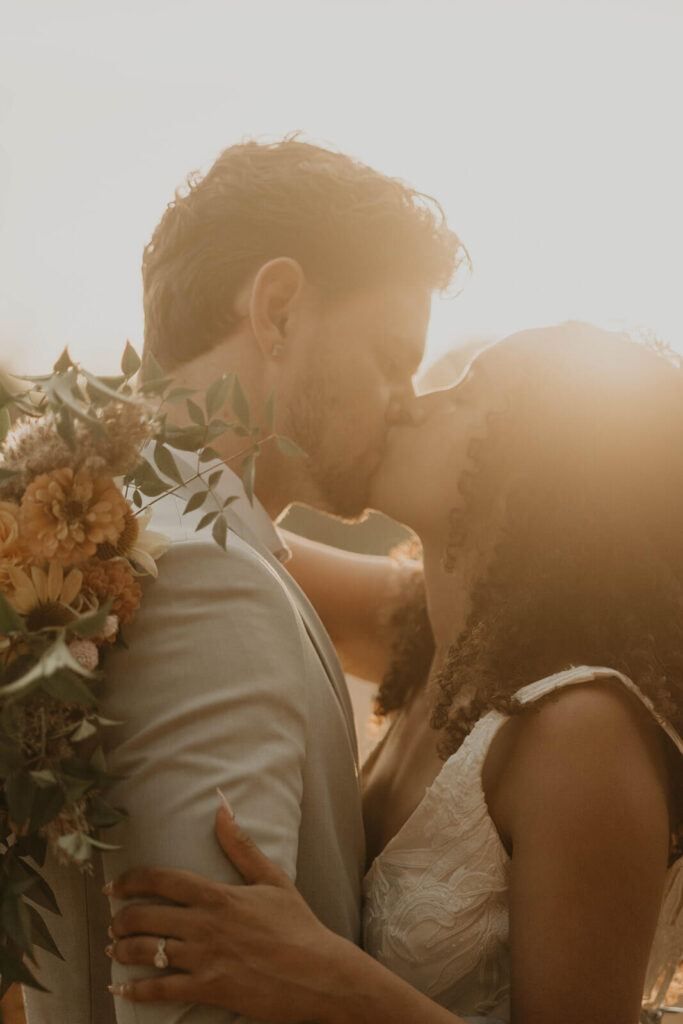 Bride and groom kiss during sunset wedding portraits in Oregon