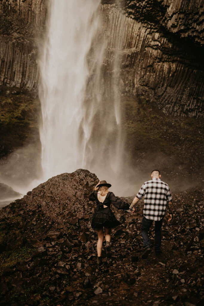 Couple holding hands, walking up the trail towards Latourell Falls