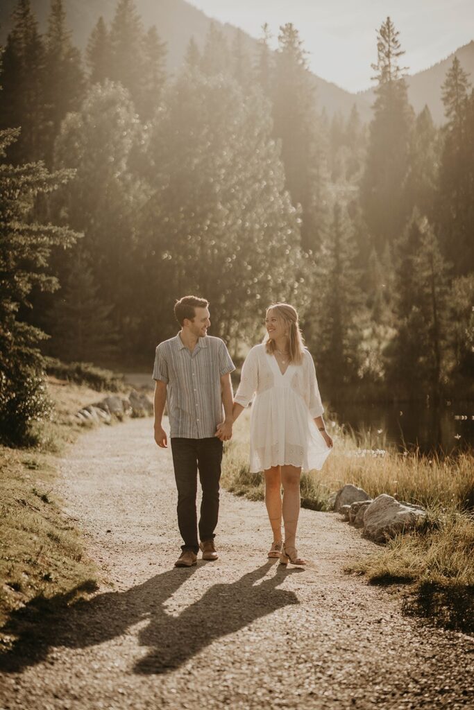 Man and woman walking hand in hand during their mountain engagement photos in Canada