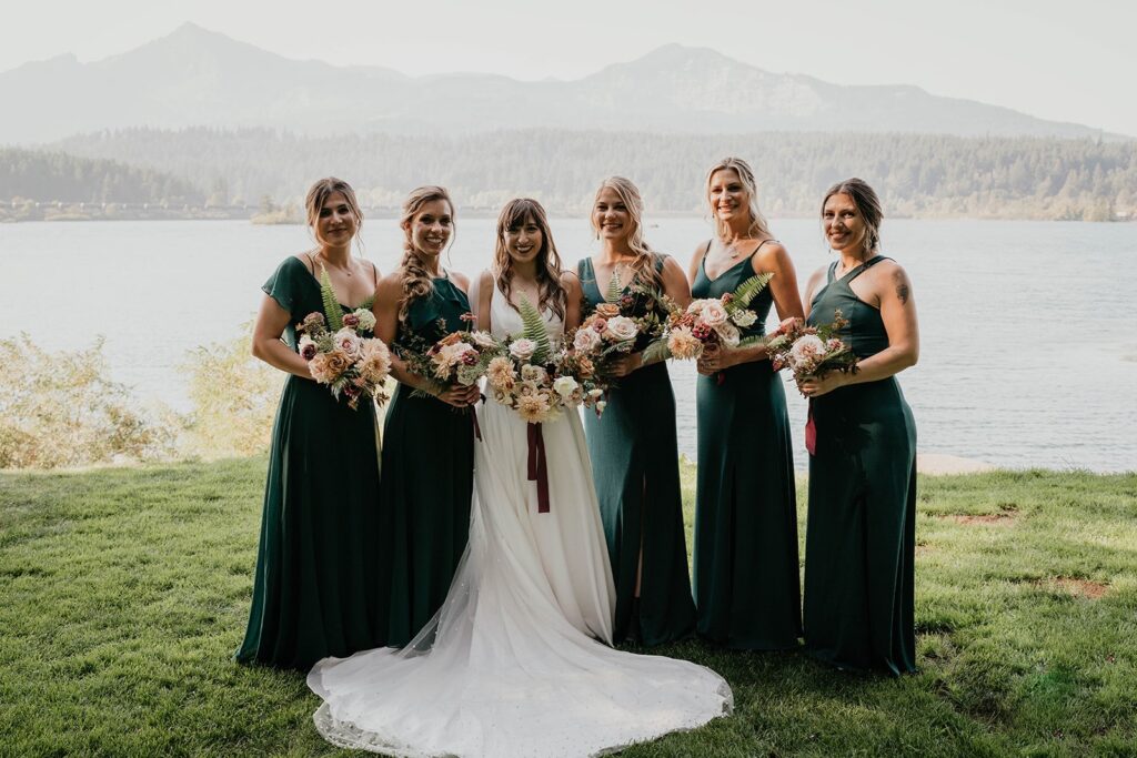 Wedding party photos by the Columbia River with bridesmaids wearing emerald green dresses