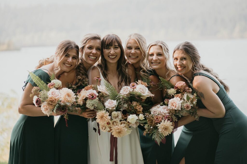 Wedding party photos by the Columbia River with bridesmaids wearing emerald green dresses