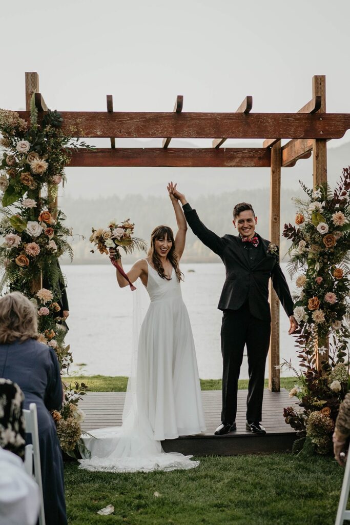 Bride and groom cheer after fall Thunder Island wedding ceremony on the Columbia River