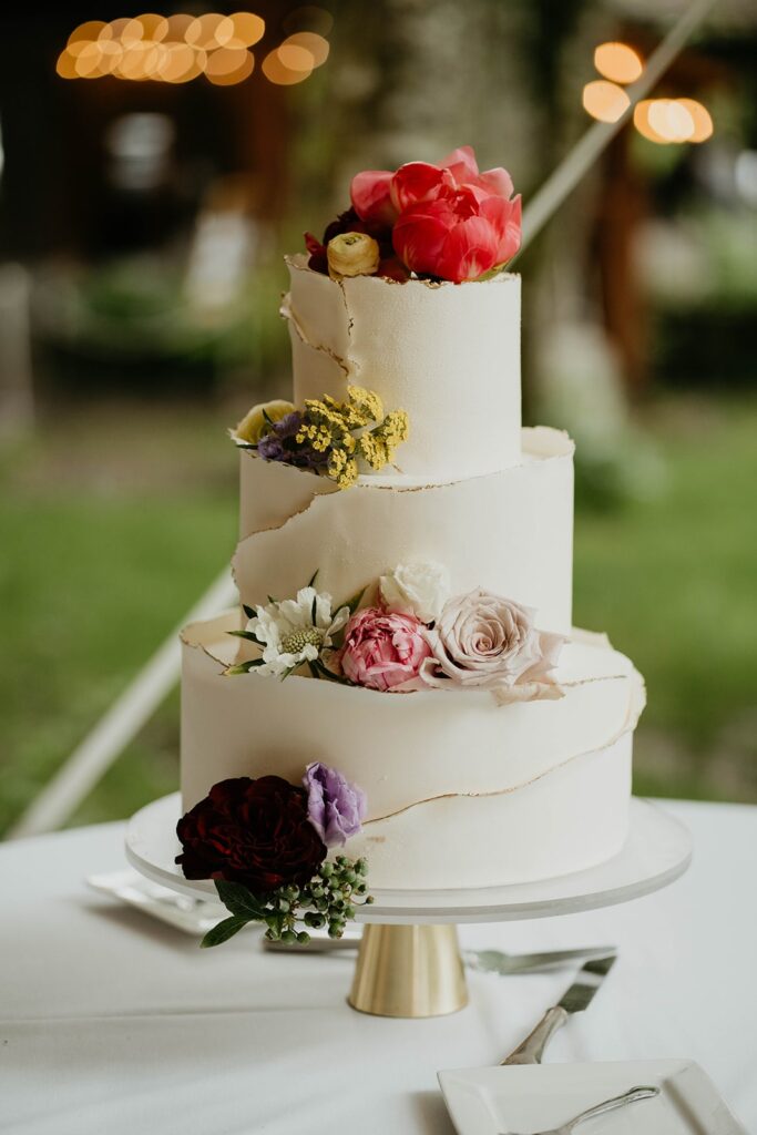 Three tier white frosted wedding cake with flowers