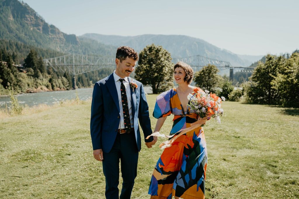 Bride and groom holding hands while walking on Thunder Island during their Cascade Locks wedding photos