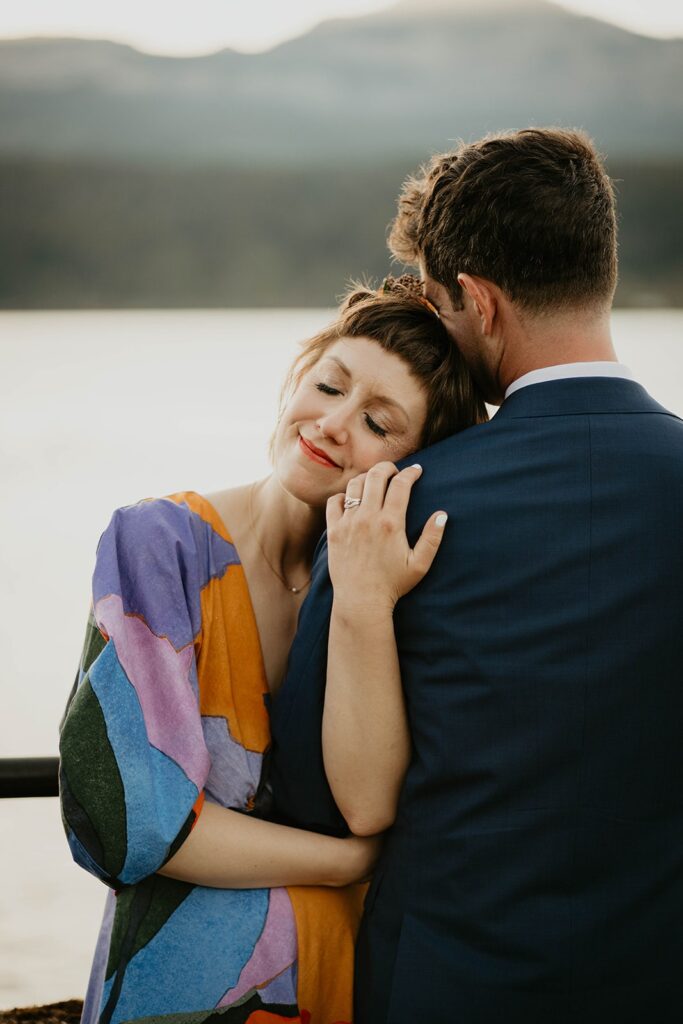 Bride rests here head on groom's shoulder during wedding portraits on Thunder Island