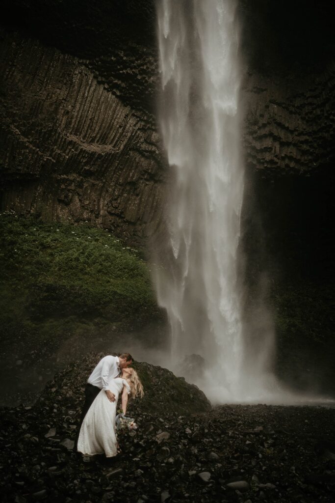 Groom dips bride for a kiss during Oregon elopement portraits at Latourell Falls