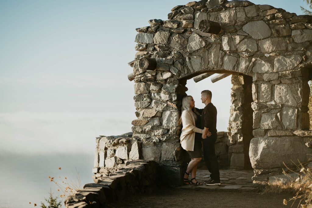 Couple standing at Cape Perpetua viewpoint for their Oregon Coast engagement photos