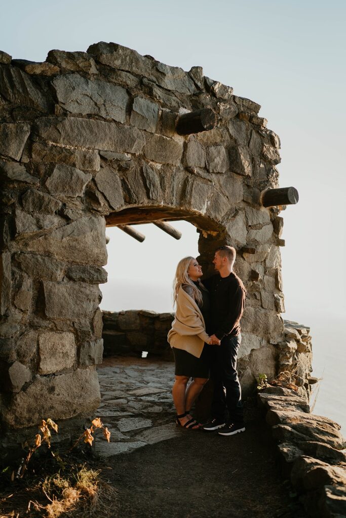 Couple standing at Cape Perpetua viewpoint for their Oregon Coast engagement photos