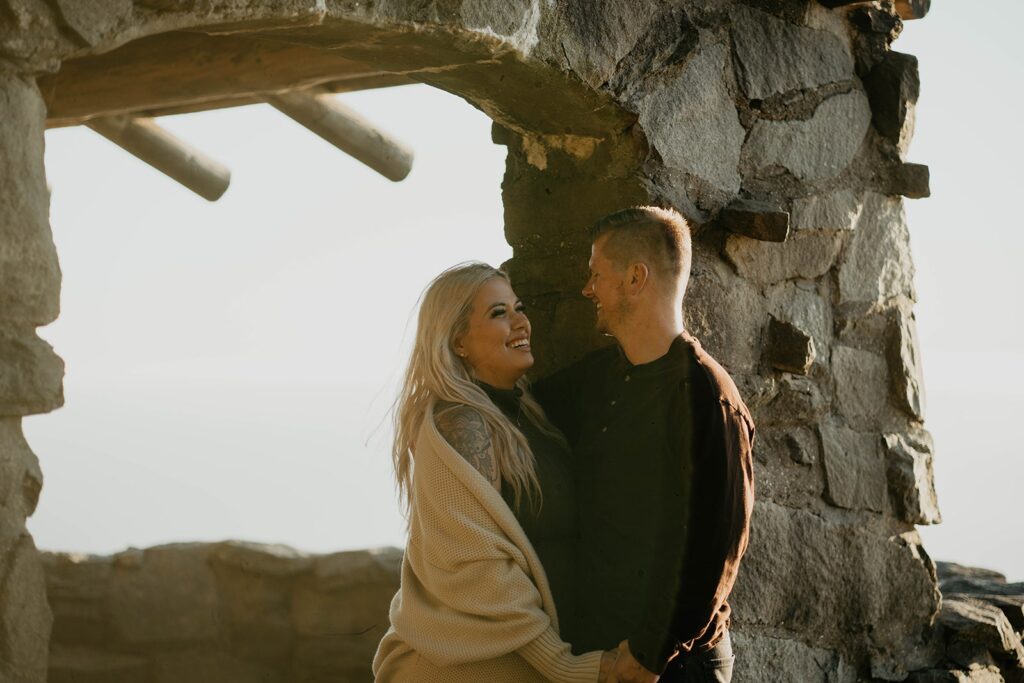 Couple standing at Cape Perpetua viewpoint for their Oregon Coast engagement photos