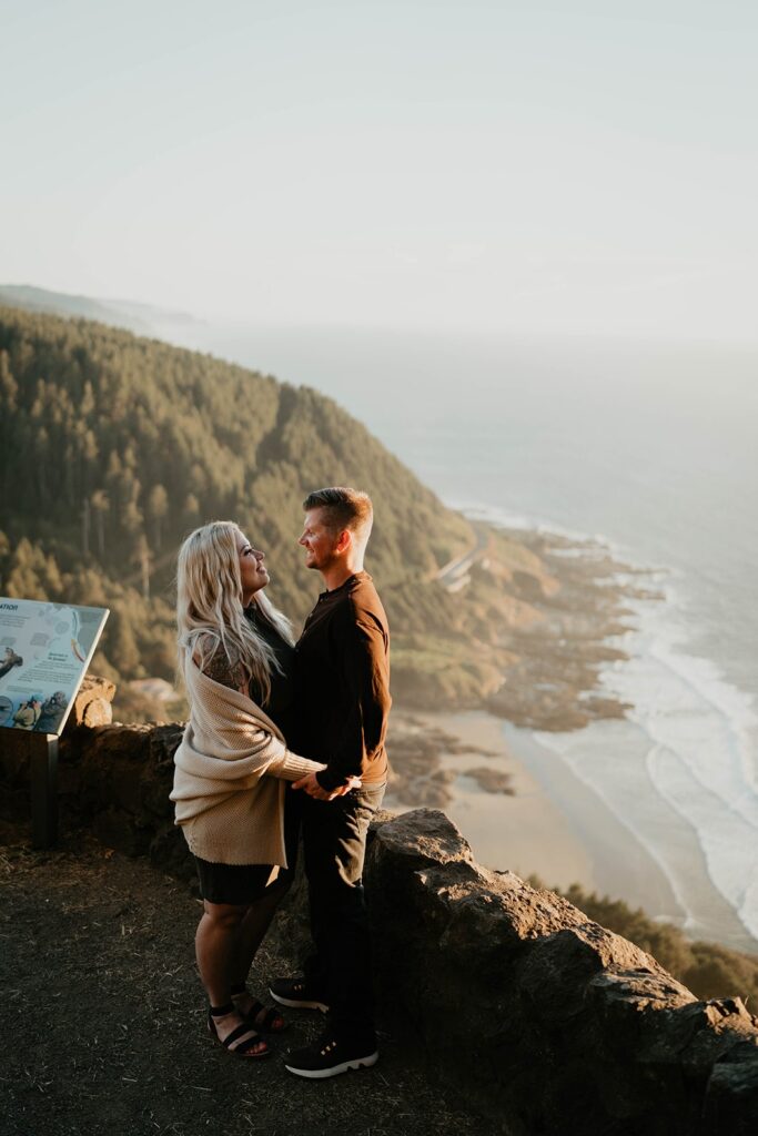 Couple standing at Cape Perpetua viewpoint for their Oregon Coast engagement photos