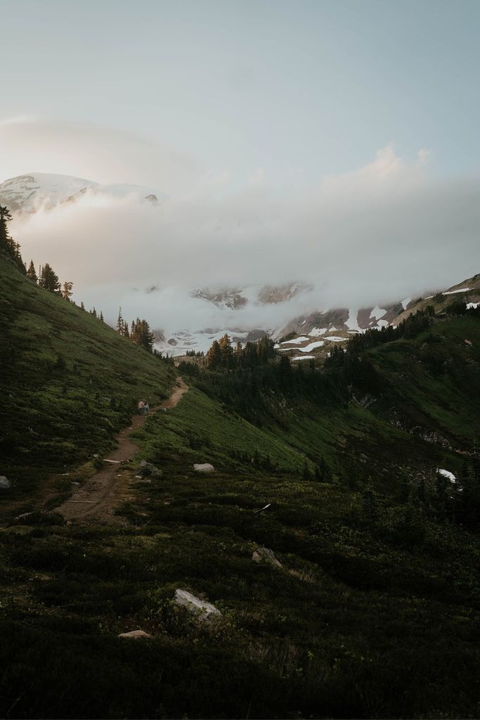 Couple walking up a trail at Mt Rainier for their hiking engagement photos