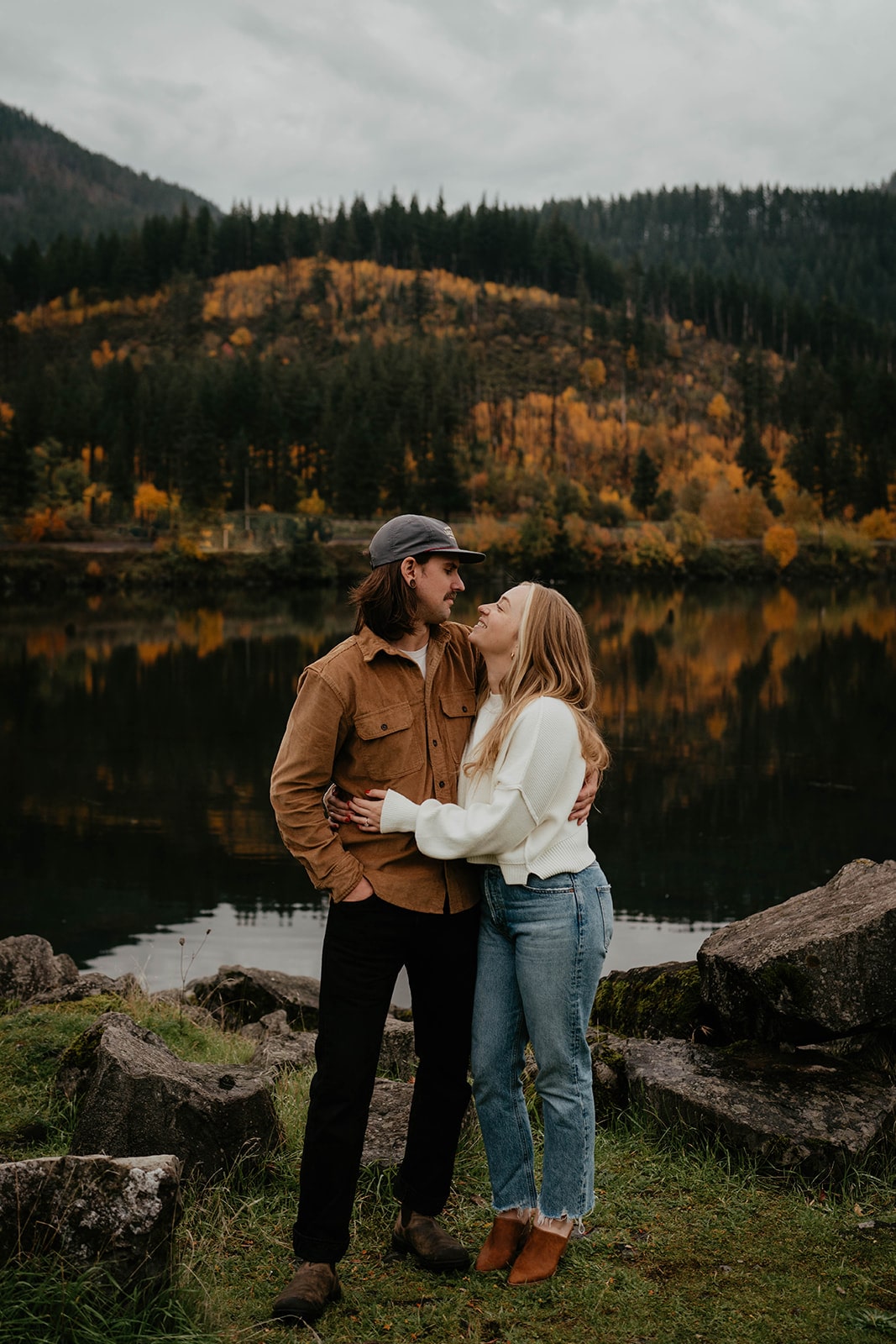 Couple stands on the bank of the Columbia River at one of the best Oregon engagement photo locations