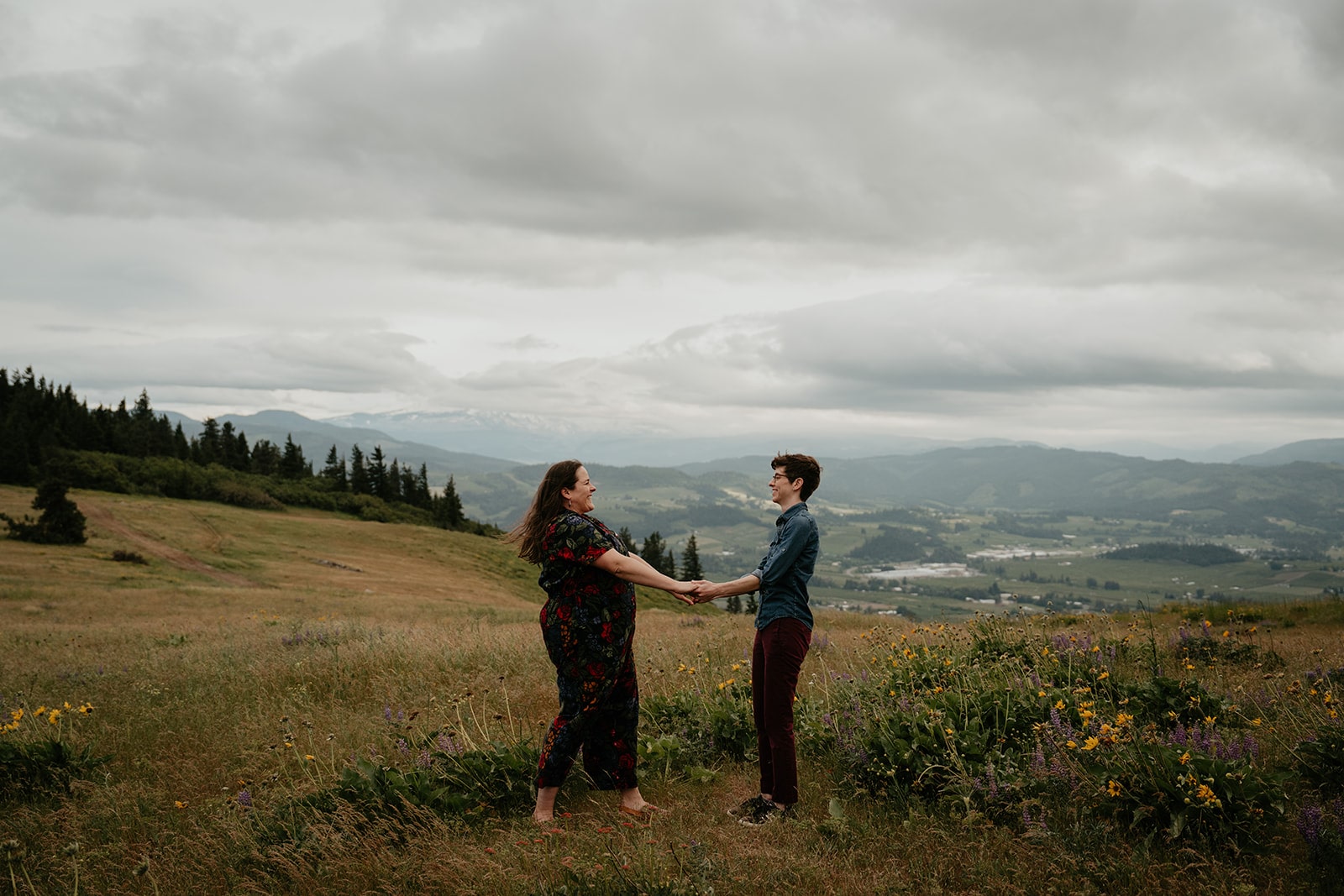 Same sex couple holds hands during their Hood River mountain engagement session in Oregon