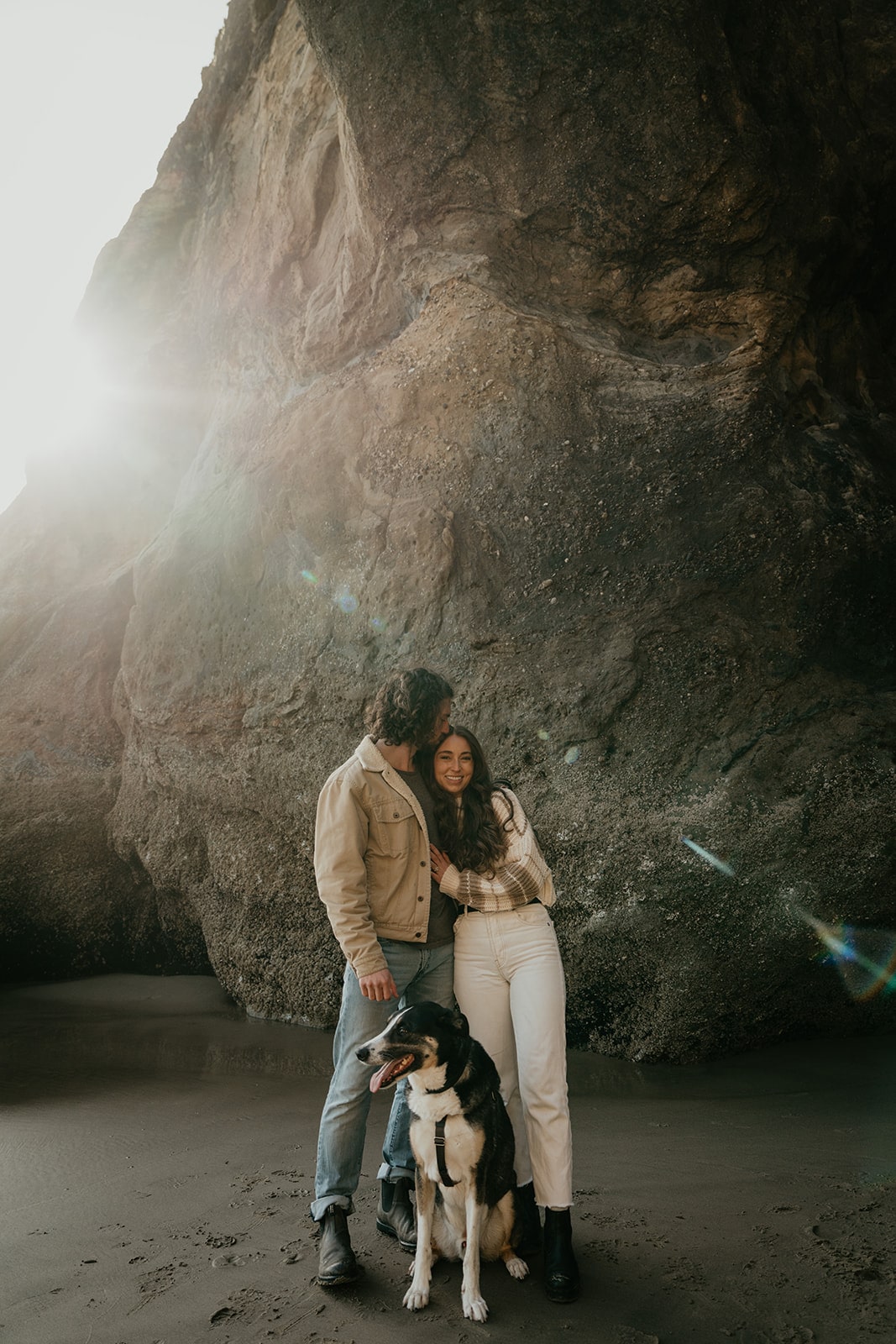 Man kisses woman on her hair during their Oregon engagement photo session at Hug Point