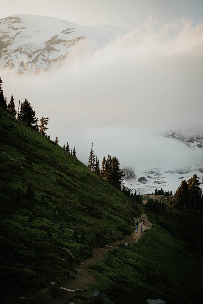 Couple walking up a trail at Mt Rainier for their hiking engagement photos