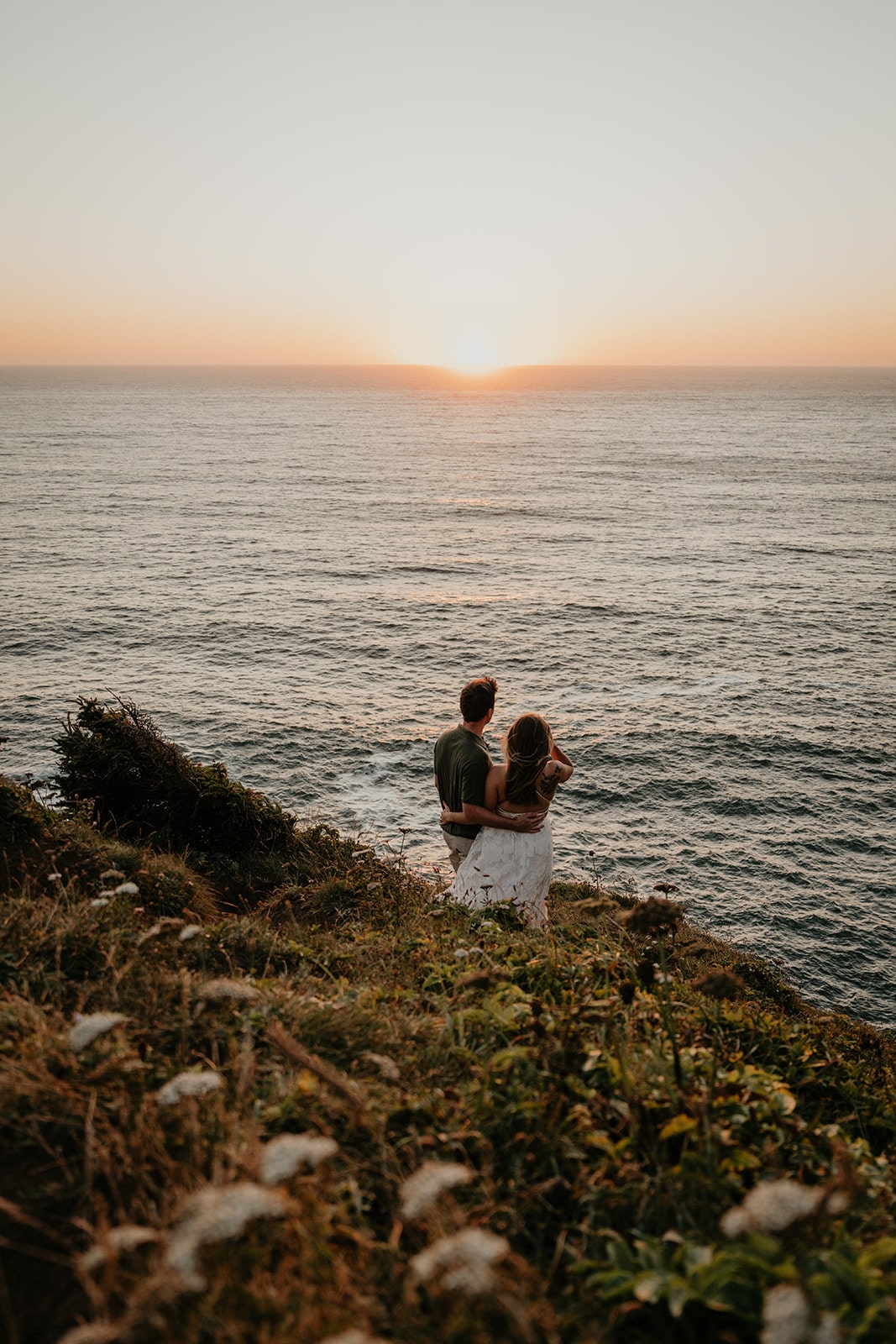 Couple looks out at the Pacific Ocean during their Oregon Coast engagement photo session