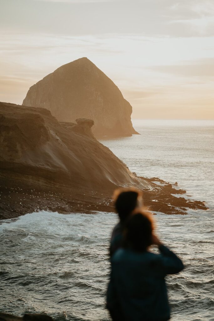 Couple looks out at the Pacific Ocean during their Cape Kiwanda sunset Oregon Coast engagement photo session