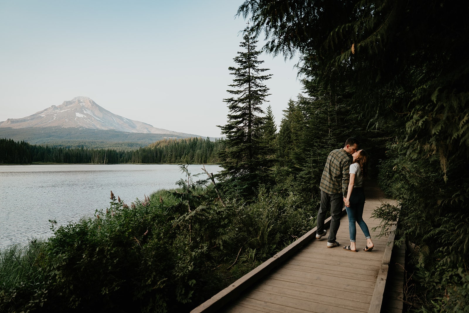 Couple kisses on the boardwalk at their Trillium Lake engagement photo session in Oregon