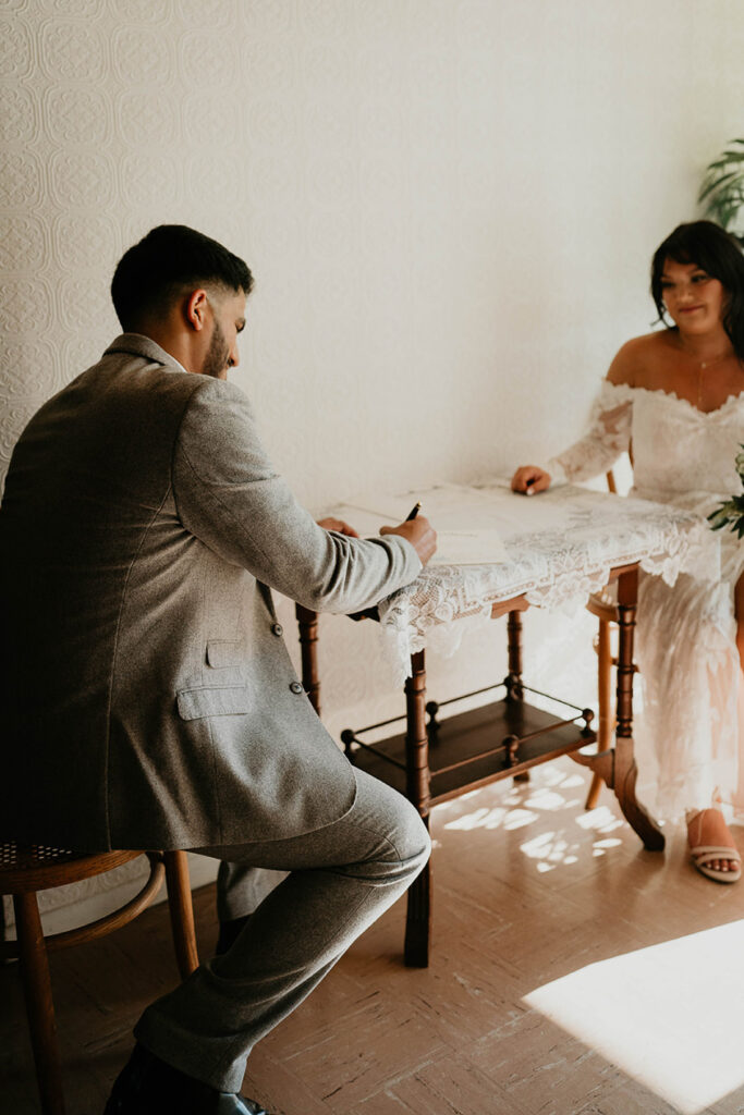 The bride and groom signing their marriage papers. 