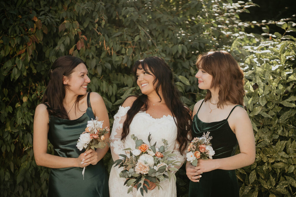 The bride taking a photo with her sisters outside. 