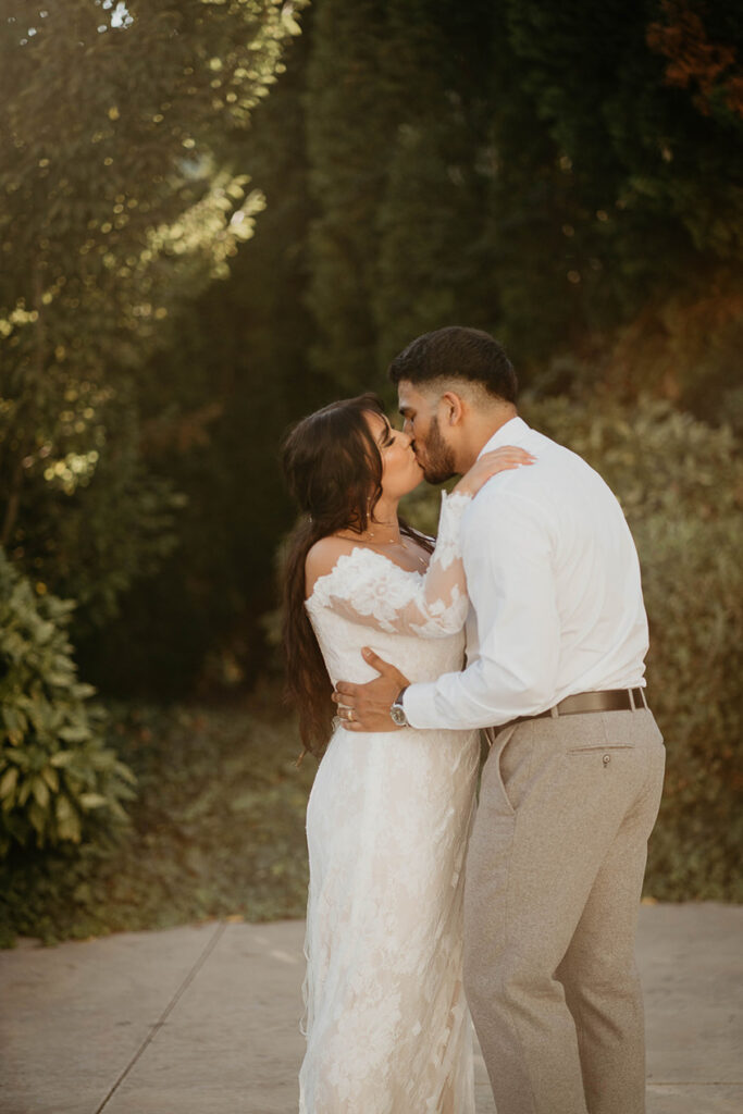 The bride and groom kissing on a patio. 