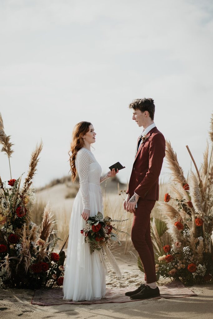 Bride and groom exchange handwritten vows during their Oregon sand dunes elopement ceremony