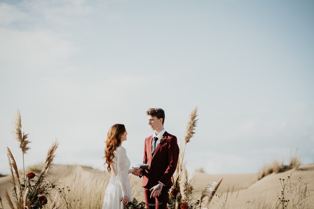 Bride and groom exchange handwritten vows during their Oregon sand dunes elopement ceremony