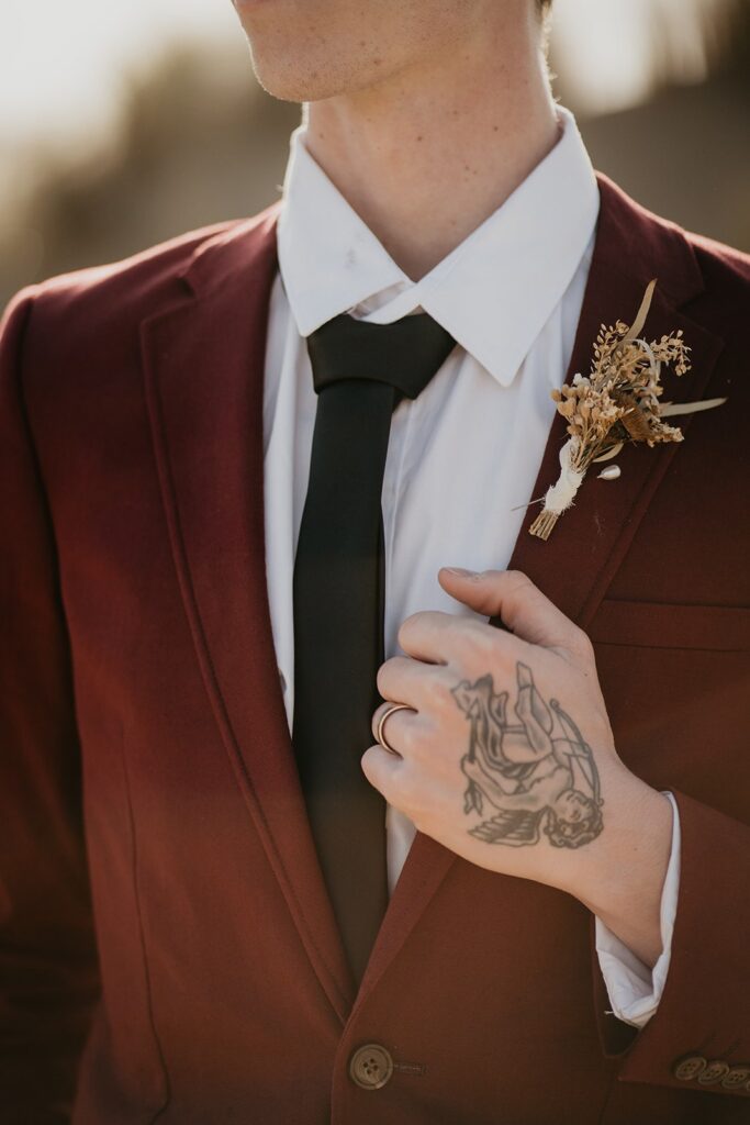 Groom wearing beige suit for Oregon sand dunes elopement