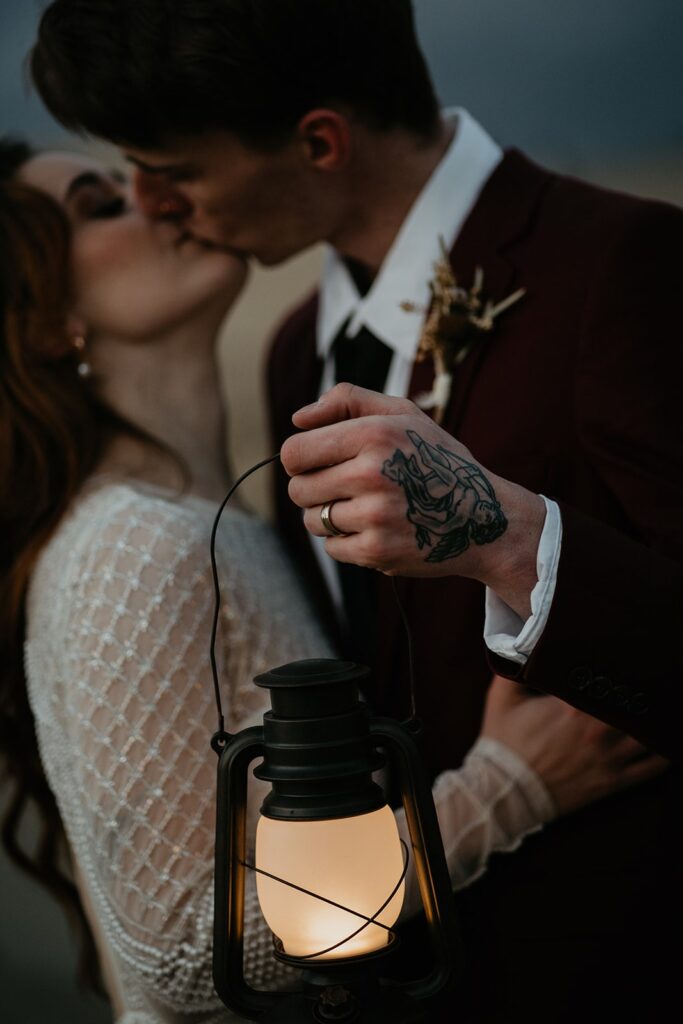 Bride and groom kiss during blue hour elopement photos on the sand dunes in Oregon