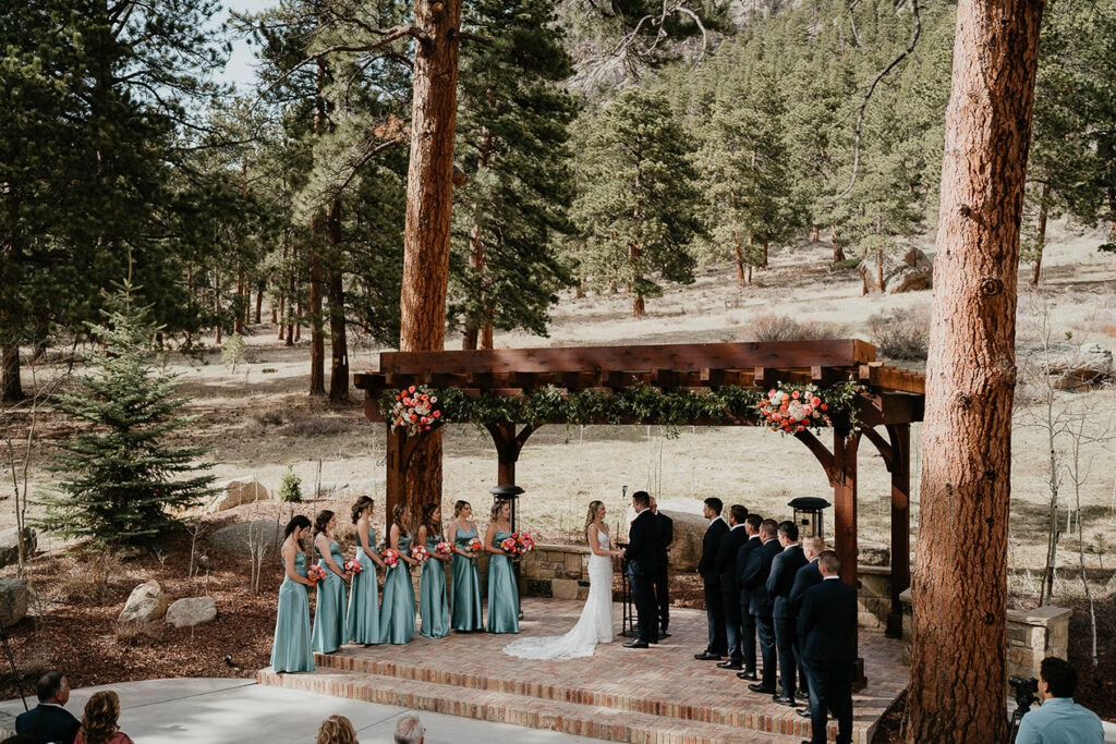 The bride and groom standing at the alter with their bridesmaids and groomsmen. 