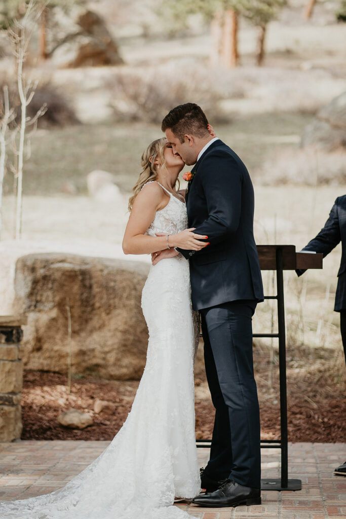 The bride and groom kissing at the alter. 