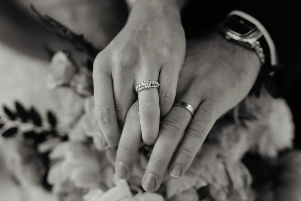 A black and white closeup of the bride and groom's wedding rings. 